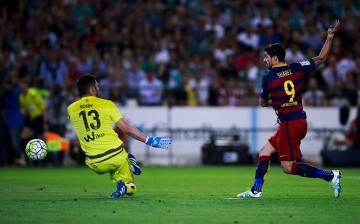 Barcelona striker Luis Suárez scores against Real Betis goalkeeper Antonio Adan.