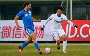 Guangzhou R&F midfielder Gustav Svensson (L) competes for the ball against Tianjin Teda's Li Benjian.