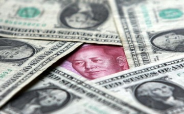  Dollars and yuan notes are seen at a bank on May 15, 2006, in Beijing, China. 