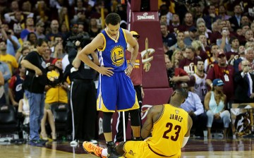 Stephen Curry is standing over the fallen LeBron James during a game.