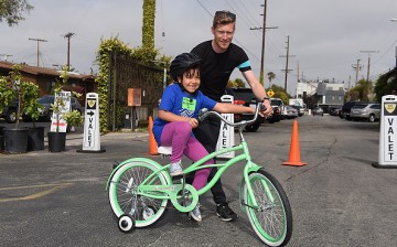 Member of team Sky Danny Van Poppe met kids from the Boys & Girls Club of South Bay test out their new bicycles in an interactive cycling course.