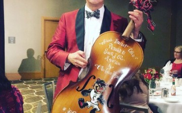 Santa Ono, the University of Cincinnati president who admitted his past battle with depression stands with his best trophy ever, a Cello trophy.