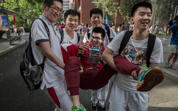 Chinese students joke with each other as they carry one student after completing the gaokao at the Beijing Renmin University Affiliated High School on June 8, 2015 in Beijing, China.