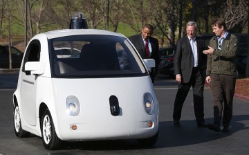 Google's Chris Urmson (R) shows a Google self-driving car to U.S. Transportation Secretary Anthony Foxx (L) and Google Chairman Eric Schmidt (C) at the Google headquarters on February 2, 2015 in Mountain View, California.