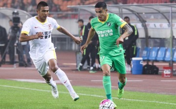 Hangzhou Greentown forward Tim Cahill (R) dribbles past Changchun Yatai's Anzur Ismailov.