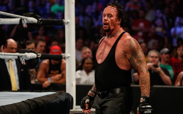 The Undertaker tries to catch his breathe during a match against Brock Lesnar.