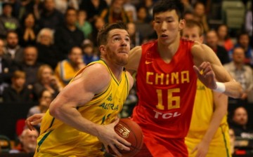 Chinese center Zhou Qi (R) defends against Australia's Lucas Walker.