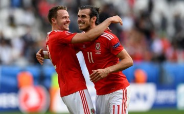Wales striker Gareth Bale (R) celebrates with teammate Chris Gunter after scoring the opening goal versus Slovakia.
