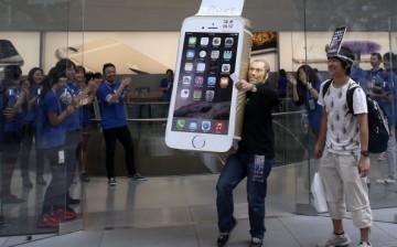 A customer wearing a Steve Jobs mask celebrates after purchasing a new iPhone at the launch of the new Apple iPhone 6 and iPhone 6 Plus at the Apple Omotesando store on Sept. 19, 2014 in Tokyo, Japan. 