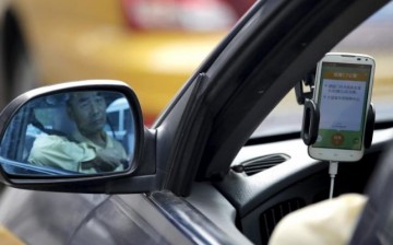 A taxi driver uses a Didi Chuxing taxi-hailing application in Beijing.