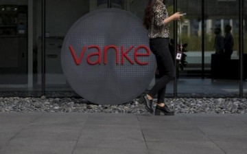 An employee walks past a logo of Vanke at its headquarters in Shenzhen, south China's Guangdong Province, Nov. 2, 2015.