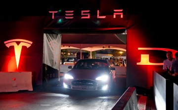 Tesla owners take a ride in the new Tesla 'D' model electric sedan after Elon Musk, CEO of Tesla, unveiled the dual engine chassis of the new Tesla 'D' model, at the Hawthorne Airport Oct.r 9, 2014 in Hawthorne, California. 