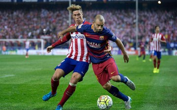 Barcelona midfielder Javier Mascherano (R) competes for the ball against Atletico Madrid's Fernando Torres.