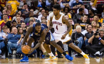 Lance Stephenson #1 of the Memphis Grizzlies posts up against Iman Shumpert #4 of the Cleveland Cavaliers during the second half at Quicken Loans Arena on March 7, 2016 in Cleveland, Ohio.