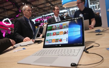 Visitors check out the Surface Book laptop at the Microsoft stand at the 2016 CeBIT digital technology trade fair on the fair's opening day on March 14, 2016 in Hanover, Germany. 
