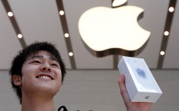 A customer shows his Apple Inc. iPhone SE after purchasing it at the company's Omotesando store on March 31, 2016 in Tokyo, Japan. 