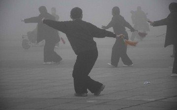 Notwithstanding the smog enveloping the area, people do their rounds of exercise on the street at Runan County of Zhumadian in Henan Province on Dec. 23, 2015.