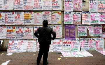 An applicant in China scours the posted ads for job information at an employment fair in Zhengzhou, Henan Province.