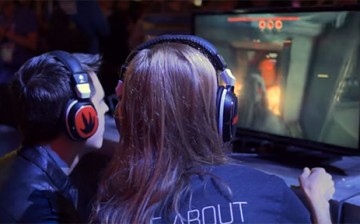 Two event goers try out the multiplayer shooter video game 