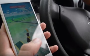 A player plays Pokemon GO in his car.