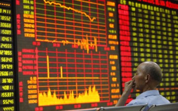 An investor watches the electronic board at a stock exchange hall on June 24, 2013, in Huaibei, China.