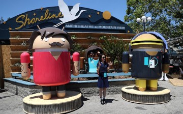 An attendee poses for a photo next to Android characters during Google I/O 2016 at Shoreline Amphitheatre on May 19, 2016 in Mountain View, California. 