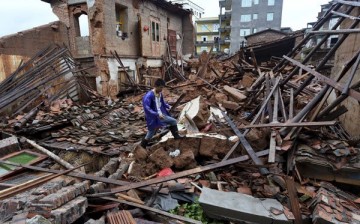 A villager walks over destroyed houses in Fujiian after heavy rains and flooding caused by typhoon Nepartak.