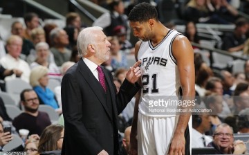 Coach Gregg Popovich talks to Tim Duncan during a Spurs home game.