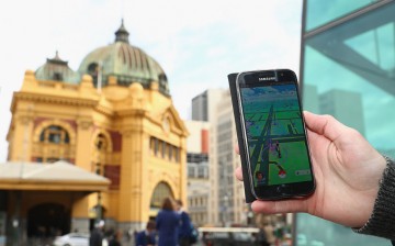 A man holds up his phone as he plays the augmented reality game Pokemon Go on July 13, 2016 in Melbourne, Australia. 