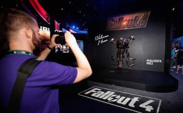 A game enthusiast takes a photograph of a 'Mr. Handy' robot in promotion to 'Fallout 4' at the Annual Gaming Industry Conference E3 at the Los Angeles Convention Center.