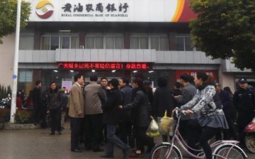 People gather outside a rural bank in Yancheng, Jiangsu Province.