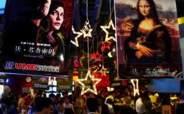 People walk below movie posters at the Xintiandi entertainment center on May 18, 2006, in Shanghai, China.
