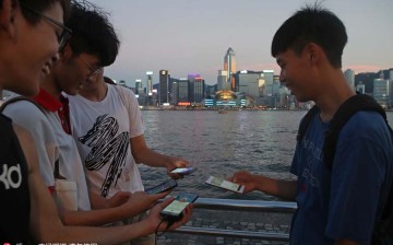 Fans maneuver their smartphones as they play Pokemon Go in Hong Kong on Monday. 