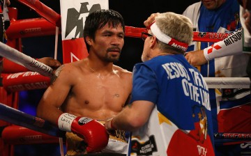 Manny Pacquiao (L) sits in his corner with trainer Freddie Roach between rounds of their welterweight championship fight against Manny Pacquiao on April 9, 2016 at MGM Grand Garden Arena in Las Vegas, Nevada.