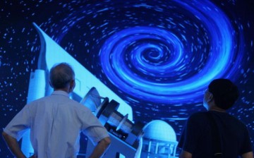 Visitors view a model of the large sky area multi-object fiber spectroscopic telescope (LAMOST) at the Shenzhen Convention & Exhibition Center on Oct. 13, 2006.