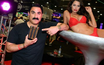  Television personality Reza Farahan and a model display his Phantom Smoke hookah products at the 29th annual Nightclub & Bar Convention and Trade Show at the Las Vegas Convention Center on March 25, 2014 in Las Vegas, Nevada.