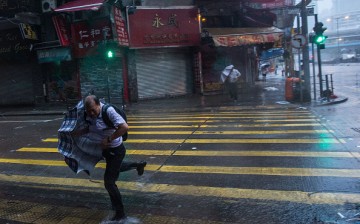 People struggle to control their umbrellas in high winds caused by Typhoon Nida on Aug. 2, 2016 in Hong Kong.