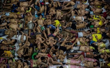 Inmates sleep on the ground of an open-air basketball court inside the Quezon City Jail in the Philippines.