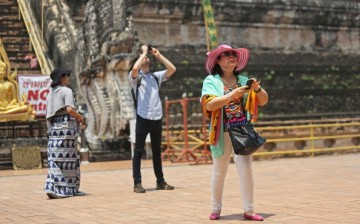 Chinese tourists take pictures at Wat Chedi Luang on April 17, 2014, in Chiang Mai, Thailand.