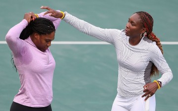 Venus Williams and Serena Williams of the United States talk during a break from a practice session ahead of the 2016 Summer Olympic Games at the Olympic Tennis Centre on August 3, 2016 in Rio de Janeiro, Brazil.