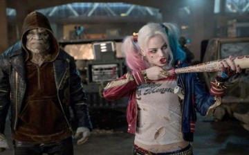 Harley Quinn, who is played by Margot Robbie, is seen in the foreground at a scene in 
