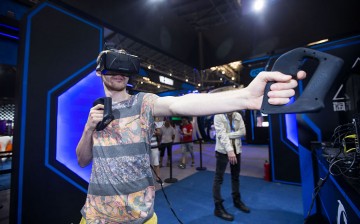 A visitor tries a virtual reality (VR) gadget at Alibaba's Taobao Maker Festival at the Shanghai World Expo Exhibition & Convention Center on July 21, 2016, in Shanghai.
