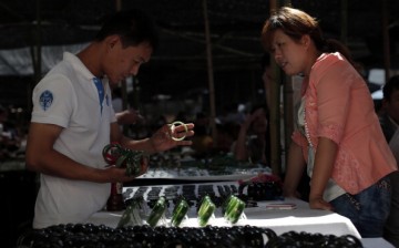 A customer selects jade bracelets at the Shifosi early market on May 27, 2013, in Shifosi town of Henan Province, China.