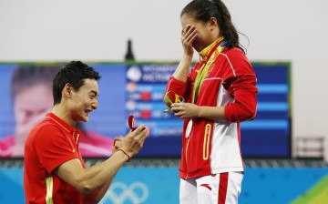 Silver medalist He Zi of China (R) receives a marriage proposal from teammate Qin Kai after the medal ceremony of the women's 3-meter springboard at the Rio Olympics on Sunday. Qin won the men's 3-meter synchronized springboard on Aug. 10. 