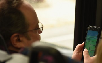 A man plays Pokemon Go while on the bus in New York City.