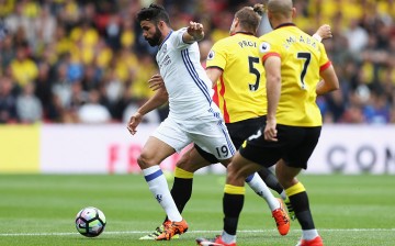 Chelsea striker Diego Costa (#19) competes for the ball against two Watford defenders.