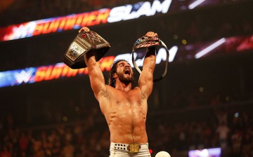 Seth Rollins celebrating at SummerSlam 2015 after defeating John Cena in a winner take all match for the WWE World Heavyweight and United States championships.