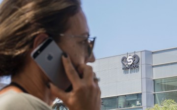 An Israeli woman uses her iPhone in front of the building housing the Israeli NSO group, in Herzliya, near Tel Aviv on August 28, 2016