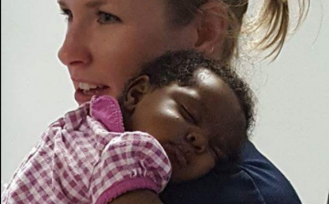 Michelle Burton, a Birmingham police officer comforts a baby on Aug 30, 2016 