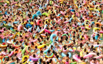 Swimmers wrestle with colourful rubber rings at a pool in Daying county, Sichuan Province, this past August, in a situation that looks anything but relaxing